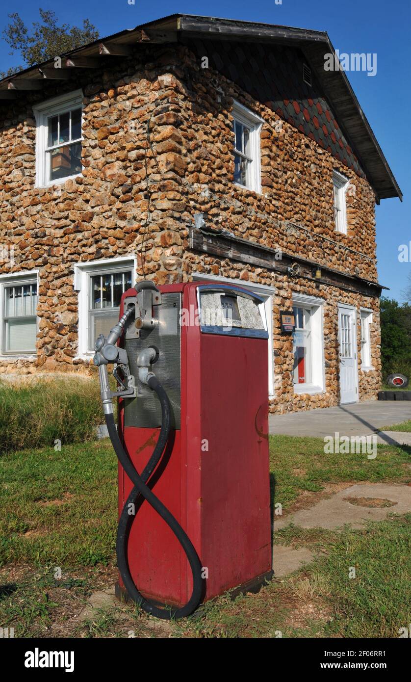 Una vecchia pompa a gas si trova davanti all'ex Henson Hotel nel villaggio Route 66 di Phelps, Missouri. L'edificio in ciottoli risale agli anni '20. Foto Stock