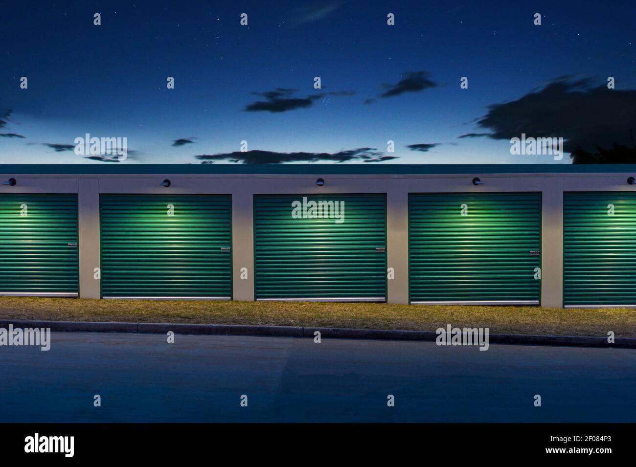 Vista creativa di porte verdi e luci incandescenti del deposito auto di notte, Stati Uniti Foto Stock