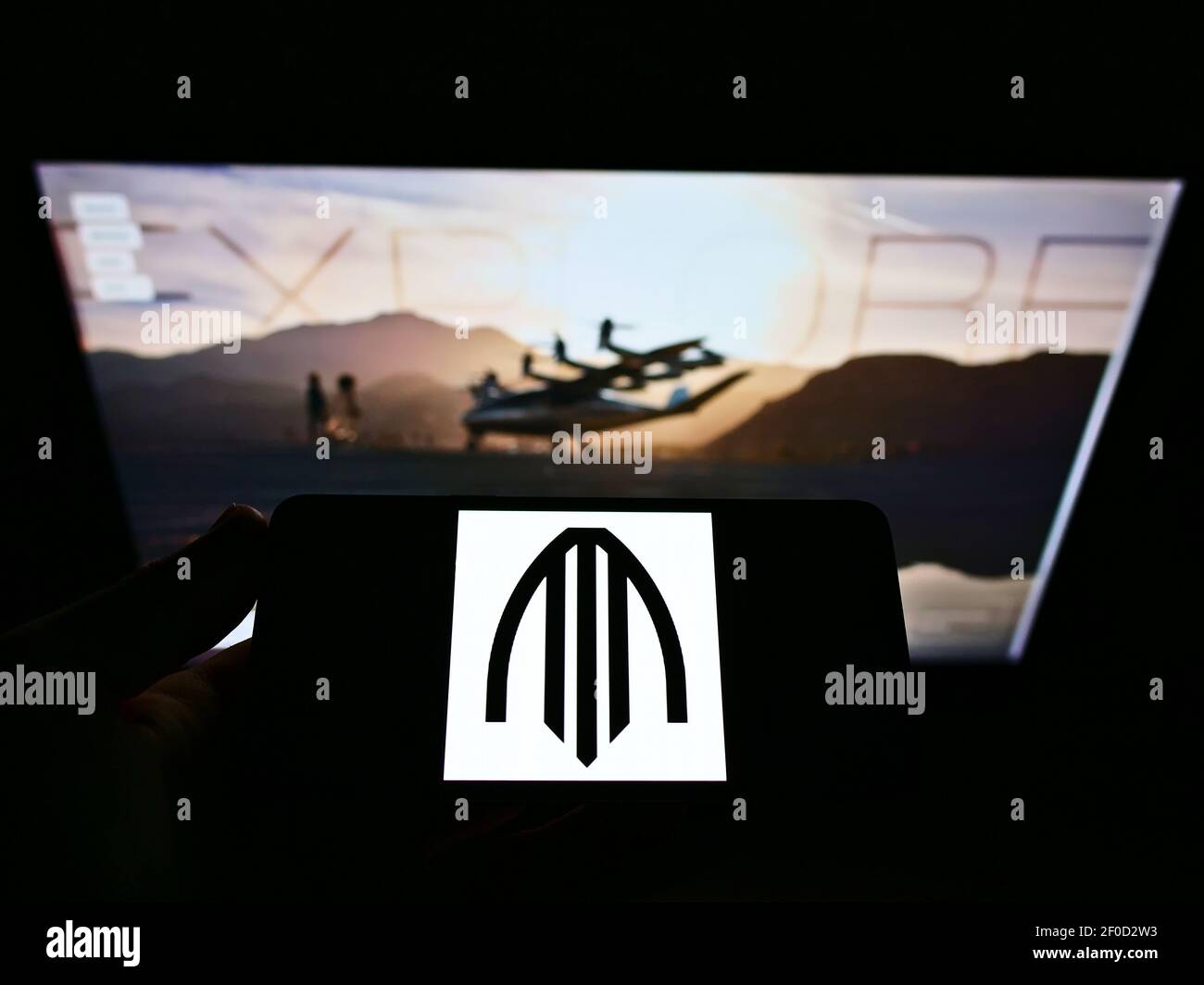 Persona che tiene il telefono mobile con il logo di affari della compagnia aerea americana di taxi Archer Aviation sullo schermo davanti alla pagina web. Mettere a fuoco il display del telefono. Foto Stock