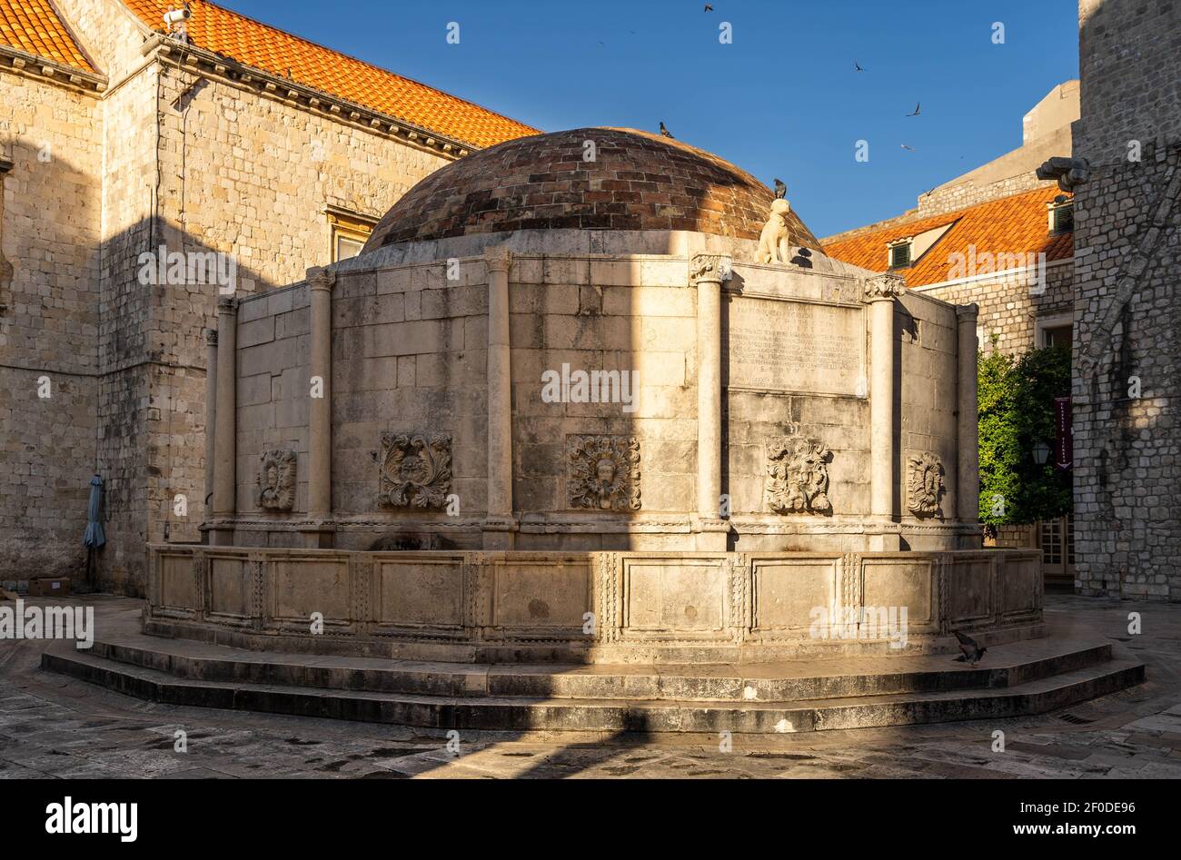 Dubrovnik, Croazia - Agosto 22, 2020: Grande Fontana di Onofrio con maschere scolpite nella città vecchia strada stradun all'alba Foto Stock