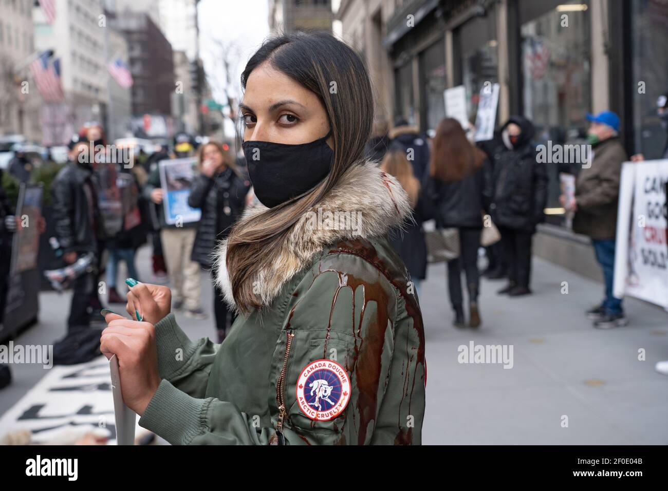 NEW YORK, NY - 6 MARZO: Un protester che indossa la copertura del cappotto dell'oca del Canada con il sangue si trova in una pozza di sangue durante una protesta dell'oca del Canada davanti al negozio di punta di Saks Fifth Avenue il 6 marzo 2021 a New York City. Attivisti per i diritti degli animali protestano pacificamente di fronte a Saks Fifth Avenue. Protestando specificamente il marchio Canad Goose, che questo rivenditore vende. I manifestanti hanno invitato Saks Fifth Avenue a smettere di vendere 'prodotti' fatti con pelliccia da chinchilla, volpi, agnelli, mink, cani da raccoon e conigli. Credit: Ron Adar/Alamy Live News Foto Stock