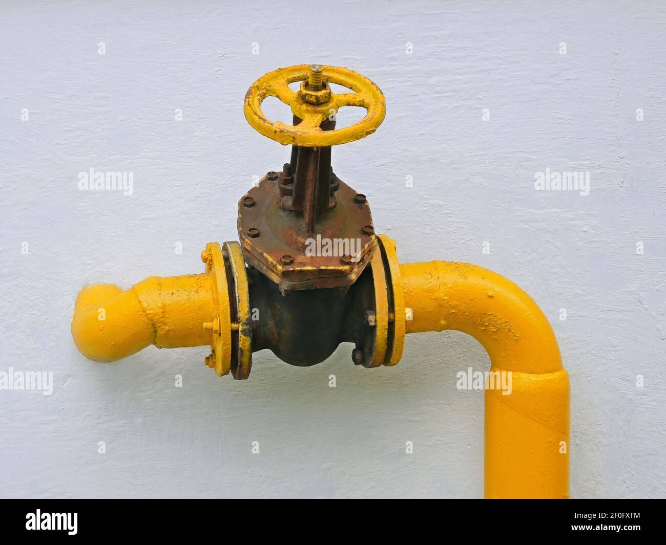 Vecchia valvola del gas fissata sul tubo che va in la parete verticale della casa Foto Stock