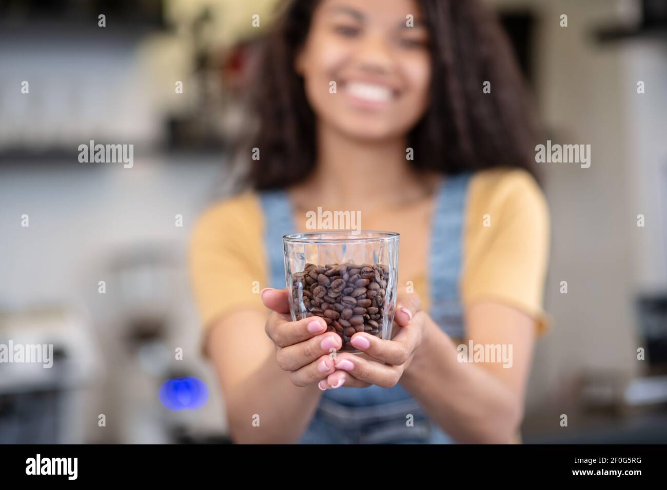 Bicchiere di chicchi di caffè in donne distese Foto Stock