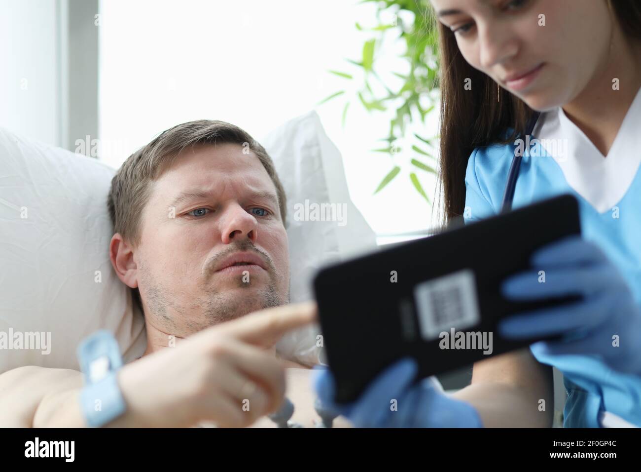 Medico che mostra i dati dei pazienti su tablet digitale in ospedale Foto Stock