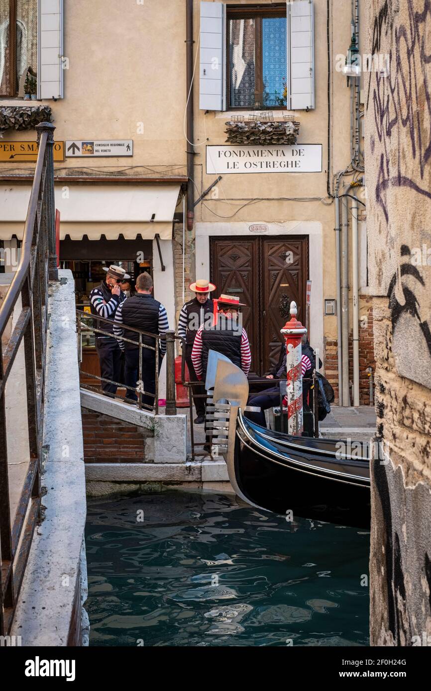 Venezia, Italia. Gruppo di Gondolieres in attesa di affari su un canale Foto Stock