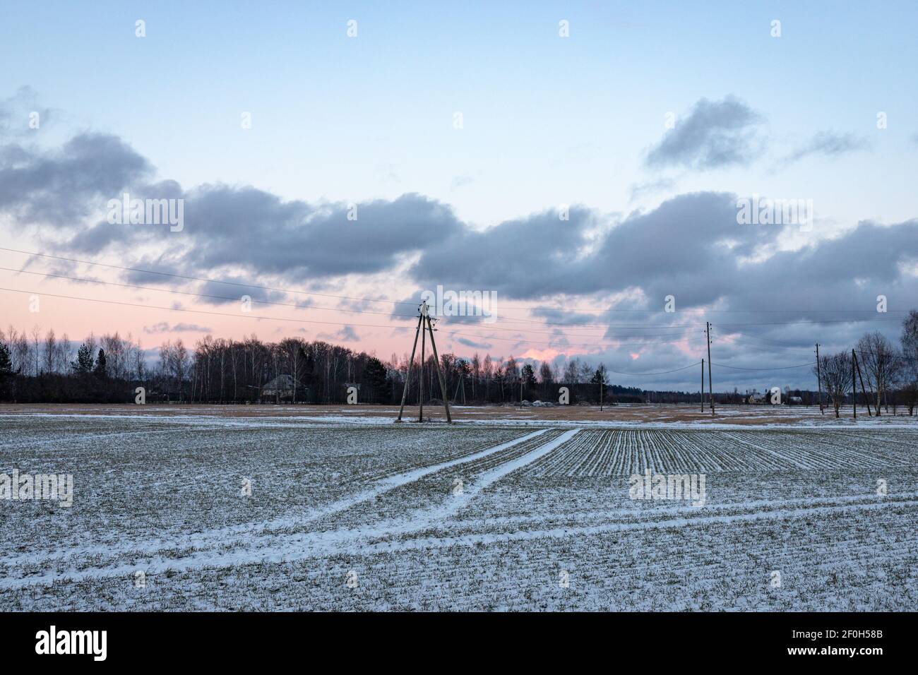 Un polo elettrico su un prato innevato. Concetto di stagione energetica e meteorologica. Copia spazio su cielo Foto Stock