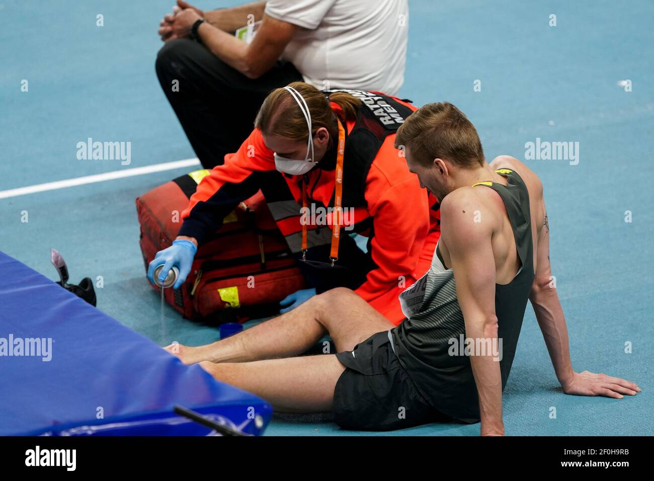 TORUN, POLONIA - 7 MARZO: Mateusz Przybylko della Germania riceve cure mediche mentre gareggia nella finale di Mens High Jump durante l'europeo Athle Foto Stock