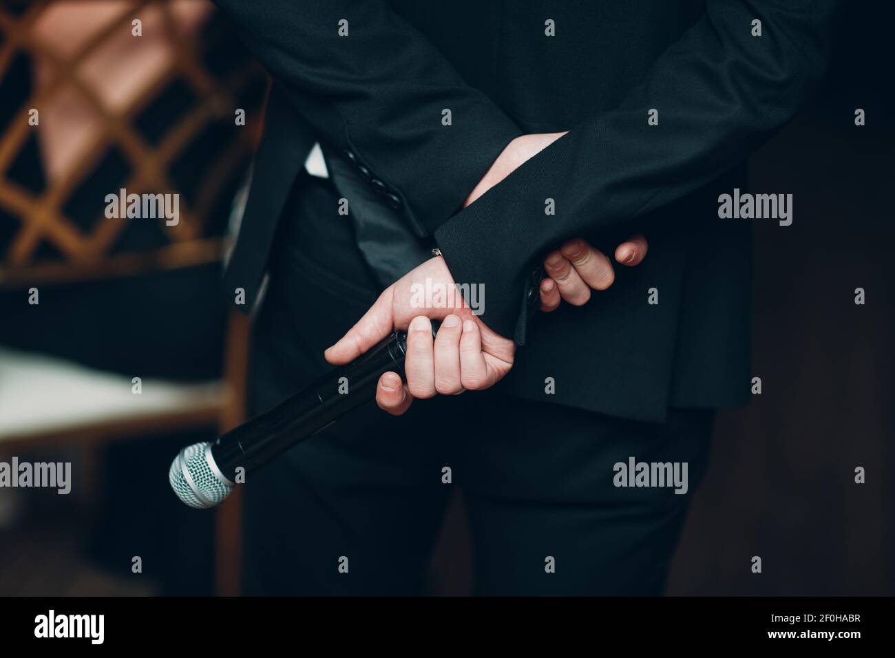 Uomo Showman altoparlante che tiene il microfono dietro il suo concetto di conferenza di affari posteriore. Foto Stock