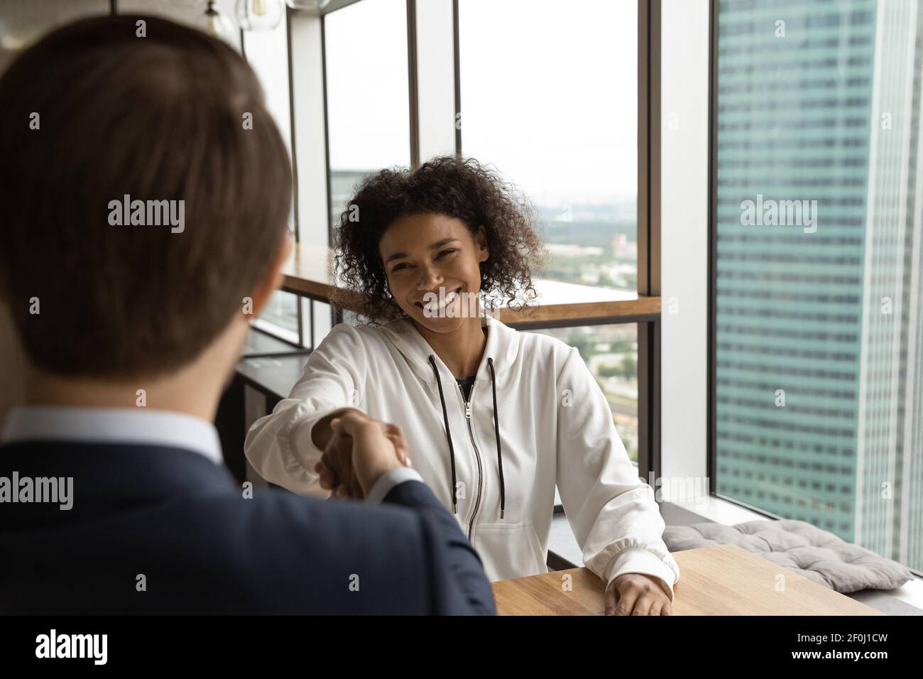 Sorridente afroamericana e manager hr scuotendo le mani Foto Stock