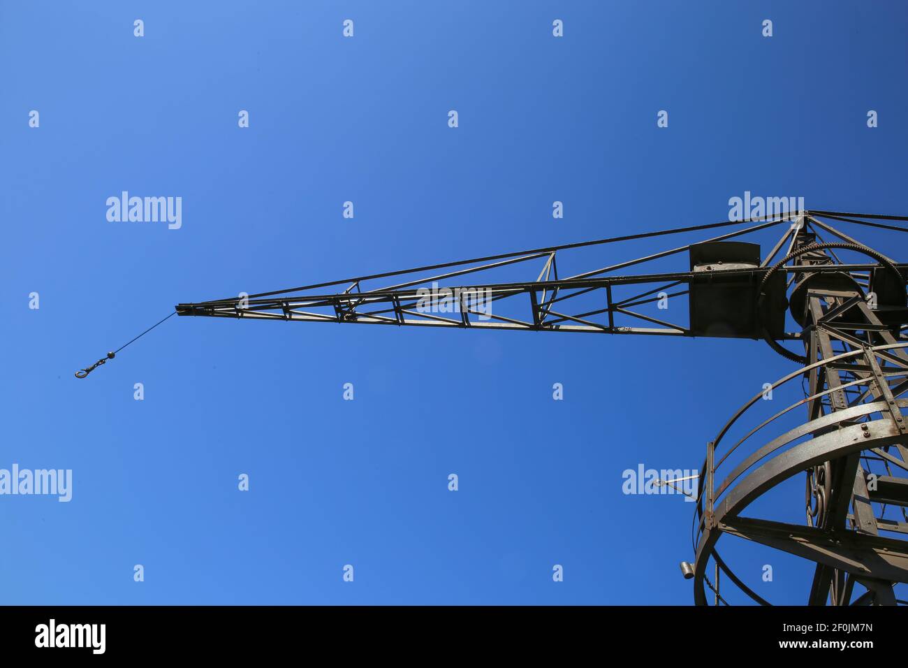 Vista ad angolo basso su una vecchia trave di gru isolata in acciaio contro cielo blu scuro senza nuvole Foto Stock