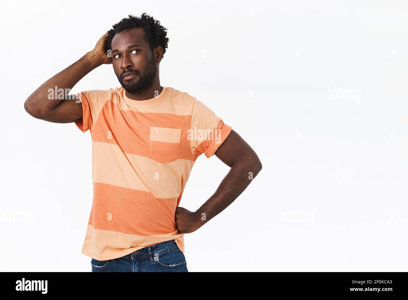 Un giovane afro-americano, accanito e dubbioso, interrogato, in una t-shirt a righe che non è indeciso ed esitante, guarda via nervosamente, spaventoso Foto Stock