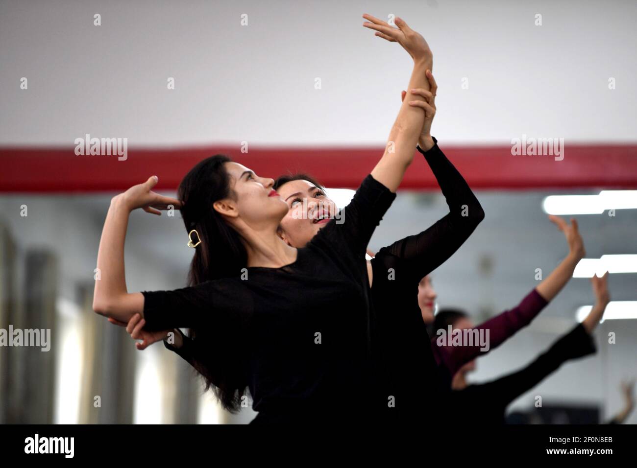 (210307) -- KASHGAR, 7 marzo 2021 (Xinhua) -- Amina Yusup guida una ballerina nella sala prove di una troupe di danza a Kashgar, regione autonoma di Xinjiang Uygur, 4 marzo 2021. Amina Yusup è il capo di una troupe di ballo in Kashgar. Si unì alla squadra di ballo quando aveva 17 anni e si esibisce sul palco per più di 20 anni.Amina è una ballerina e un attivo sostenitore della danza tradizionale. Ora sta studiando coreografia, sperando di innovare la danza popolare. Dopo essere diventato il capo della troupe di ballo in 2020, Amina ha messo più sforzi nell'organizzazione dei membri alla pratica Foto Stock