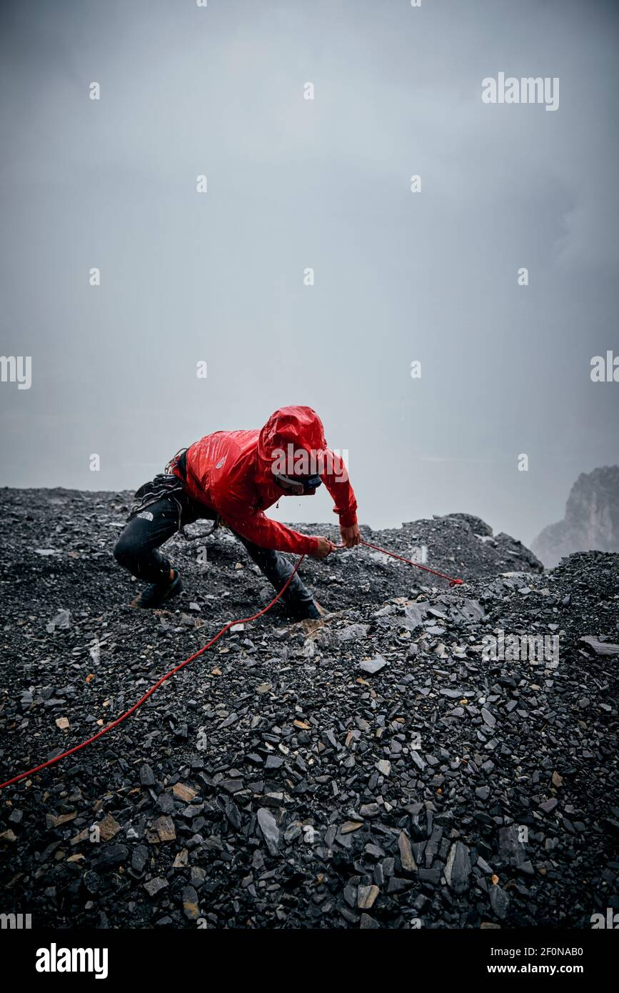 Uomo sotto tempesta mentre si arrampica sulla parete nord dell'Eiger, Svizzera Foto Stock