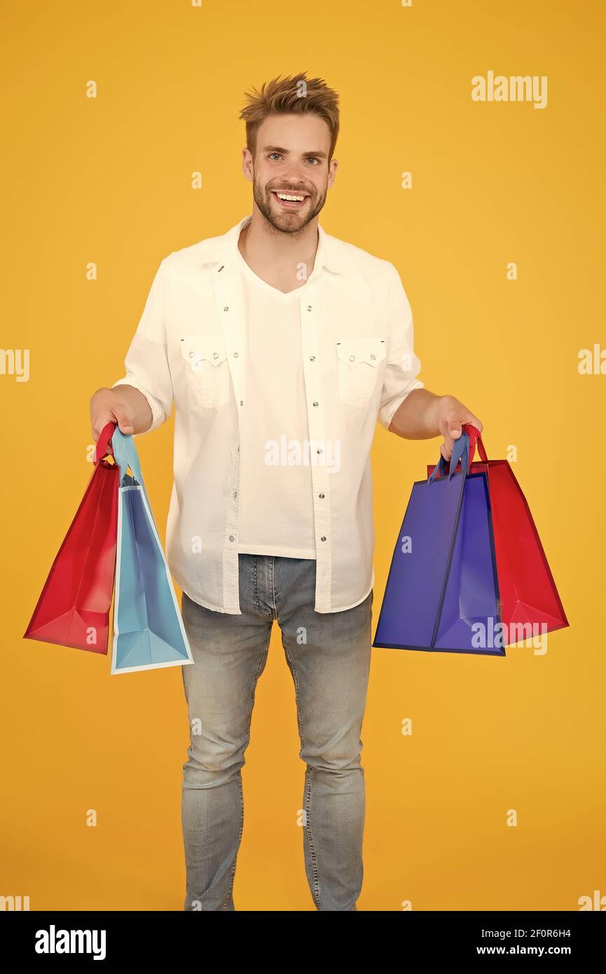 Il modo migliore per rilassarsi. Come risparmiare denaro durante la vendita. Concetto di cyber monday. Articoli per uomo. Ragazzo felice del suo acquisto. Shopping online di successo. Shopping maschile in possesso di pacchetti. Shopping bag con merci. Foto Stock