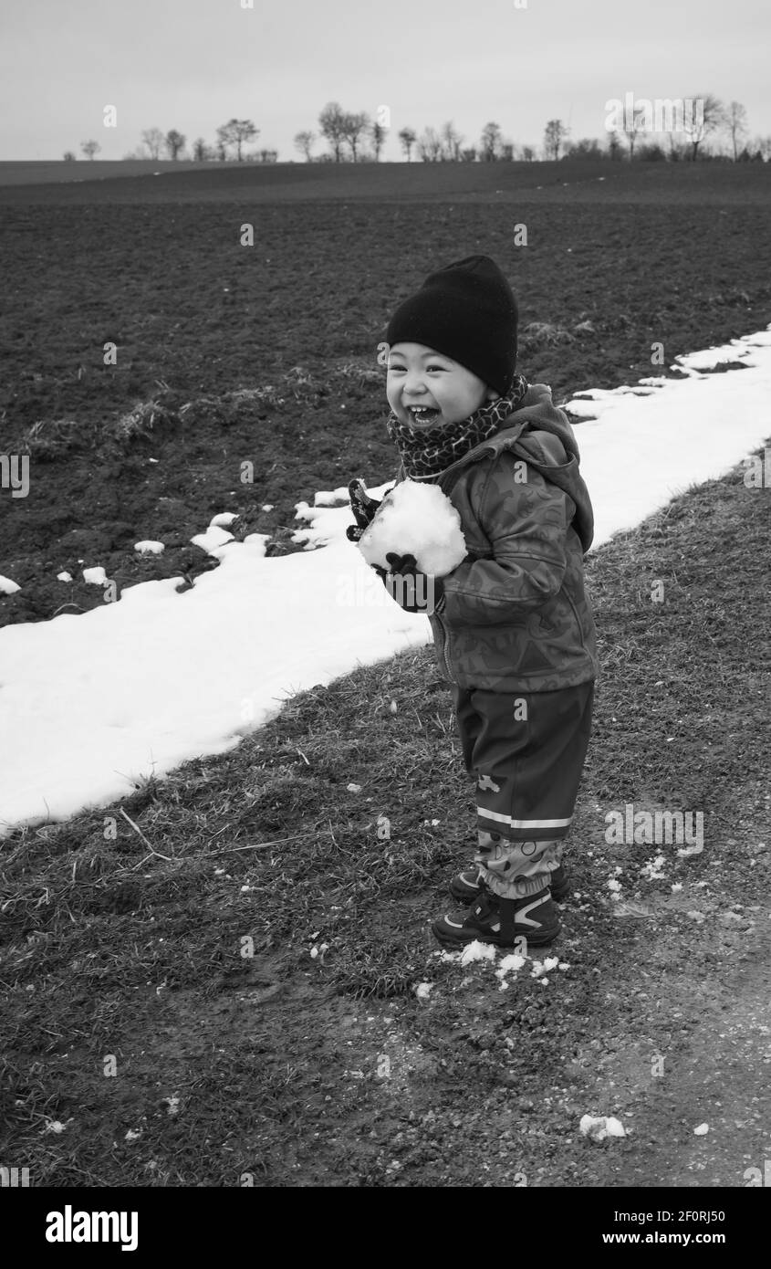 Bambino, ragazzo, 18 mesi, multietnico, gioca con palle di neve, Ride, Blaubeuren, Baden-Wuerttemberg, Germania Foto Stock