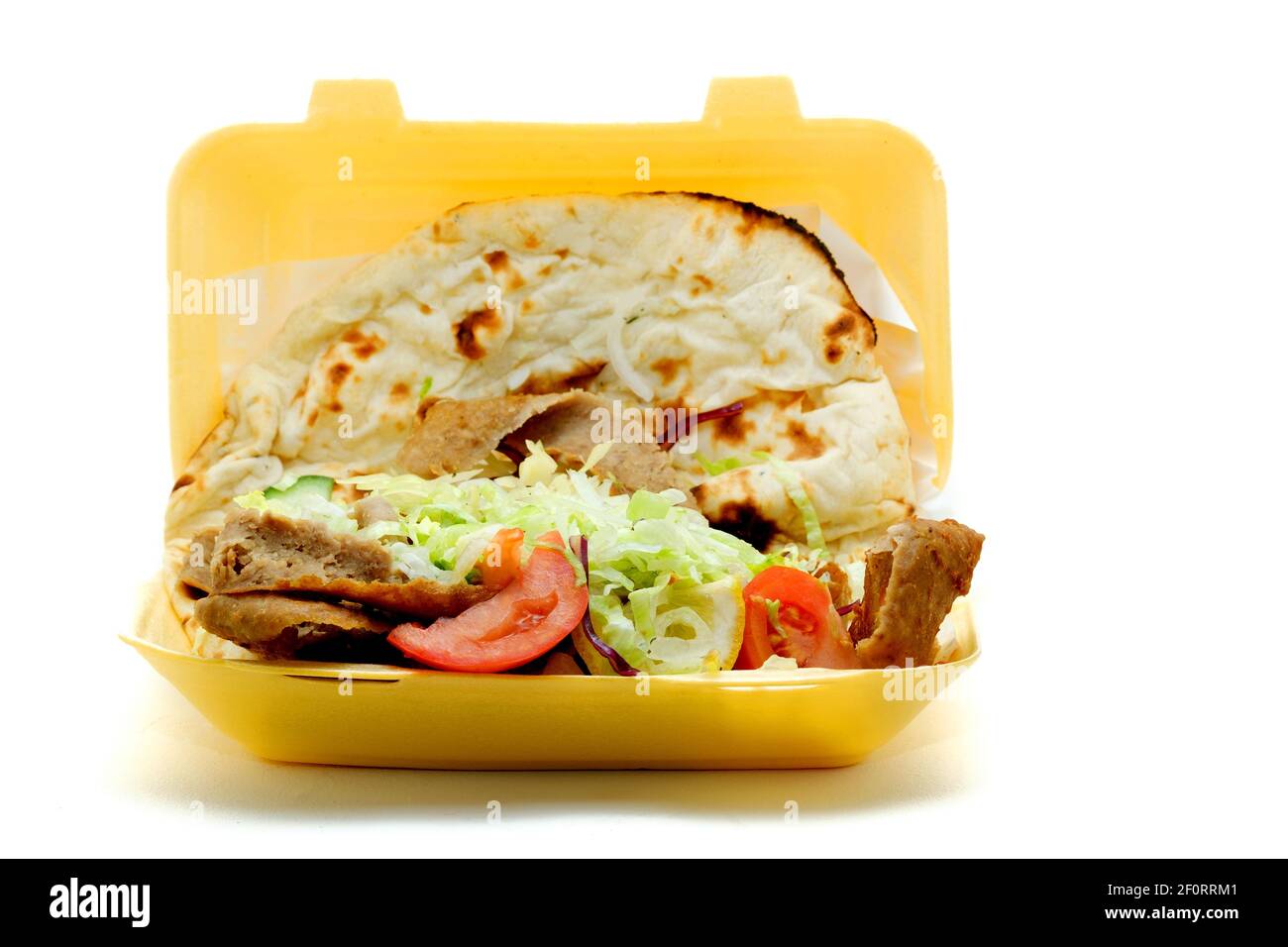 Un doner Kebab da asporto, o kebab donatore, servito con insalata e avvolto in un pane Nan. Il kebab è stato venduto in un contenitore monouso in polistirene. Foto Stock Un doner Kebab da asporto, o kebab donatore, servito con insalata e avvolto in un pane Nan. Il kebab è stato venduto in un contenitore monouso in polistirene. Foto Stock