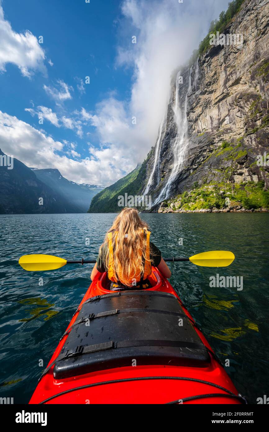 Giovane donna in kayak, cascate di Seven Sisters, Geirangerfjord, vicino a Geiranger, Norvegia Foto Stock