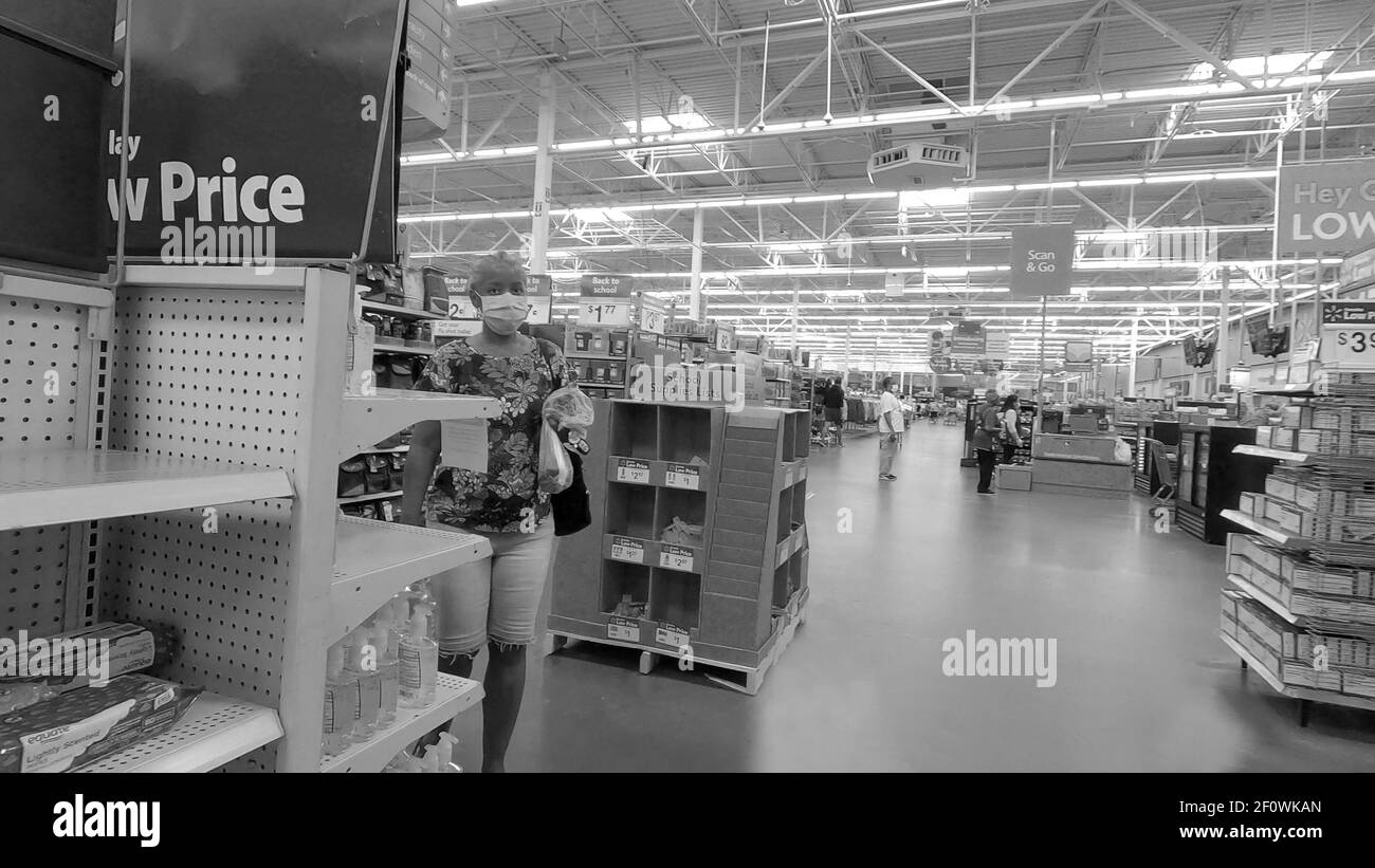 Centerville, GA / USA - 07 25 20: Cliente che porta oggetti che indossano una maschera in Walmart in bianco e nero durante la pandemia del covid-19 Foto Stock