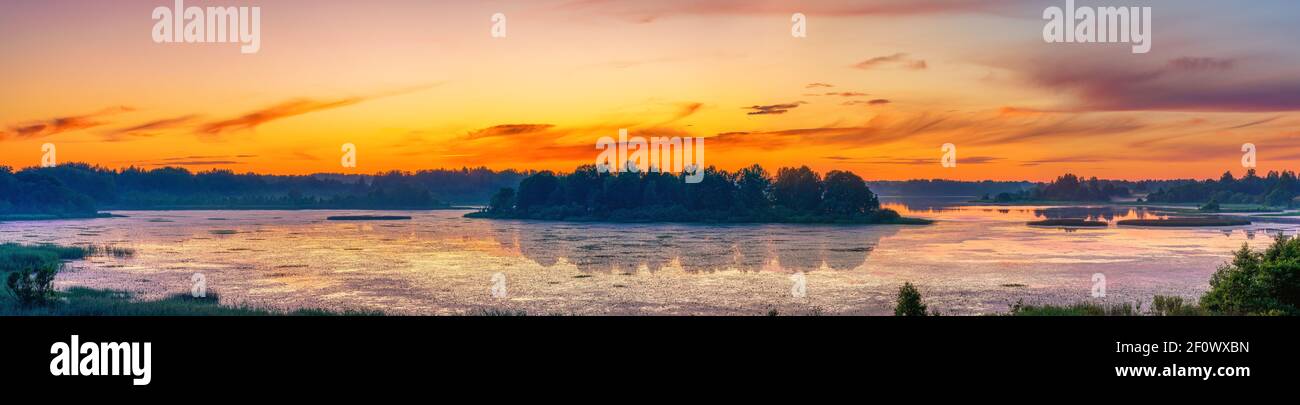 Bellissimo paesaggio con colorato tramonto sul lago di foresta Foto Stock