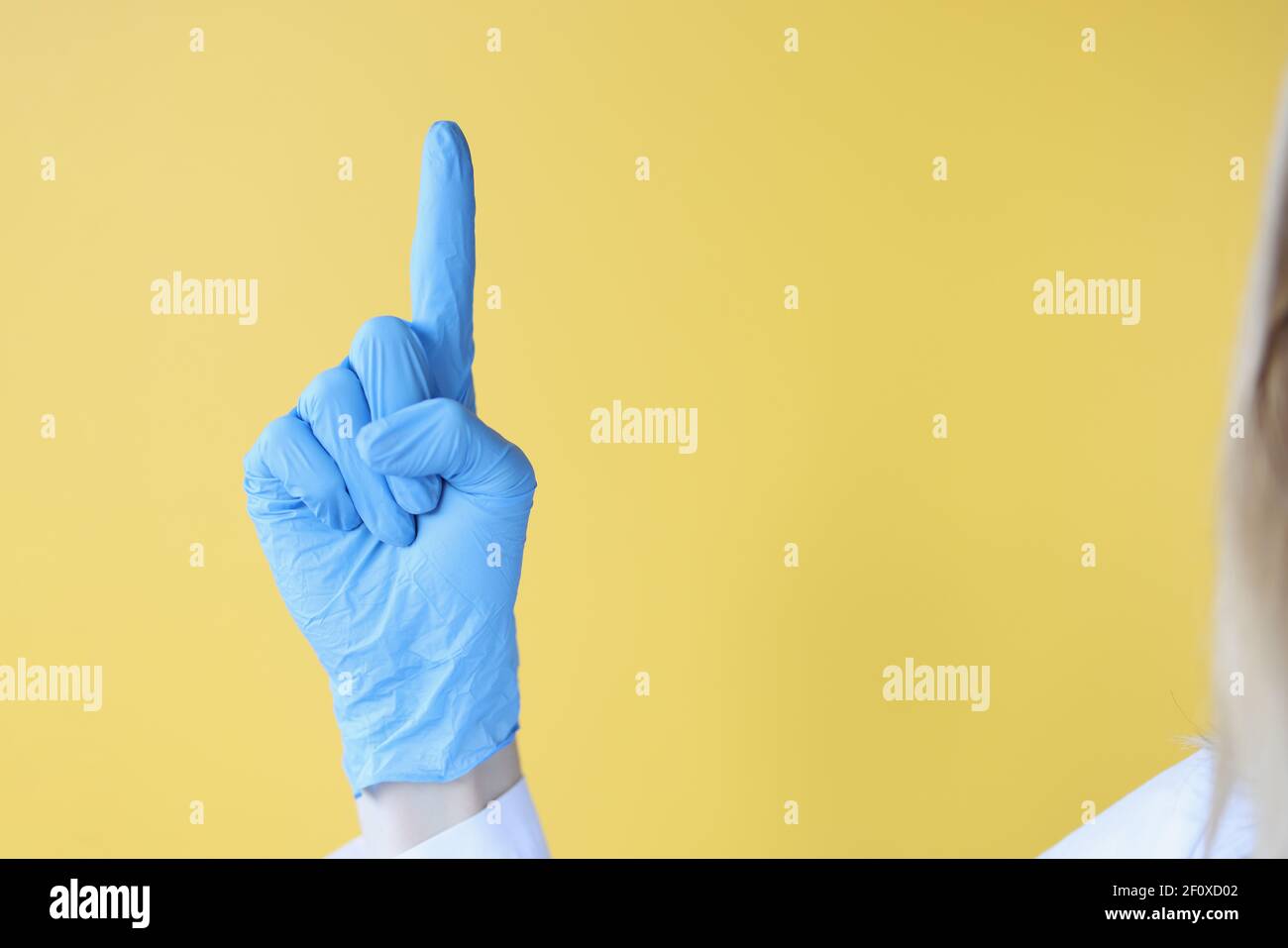 Il medico tiene il pollice in guanto medico protettivo Foto Stock
