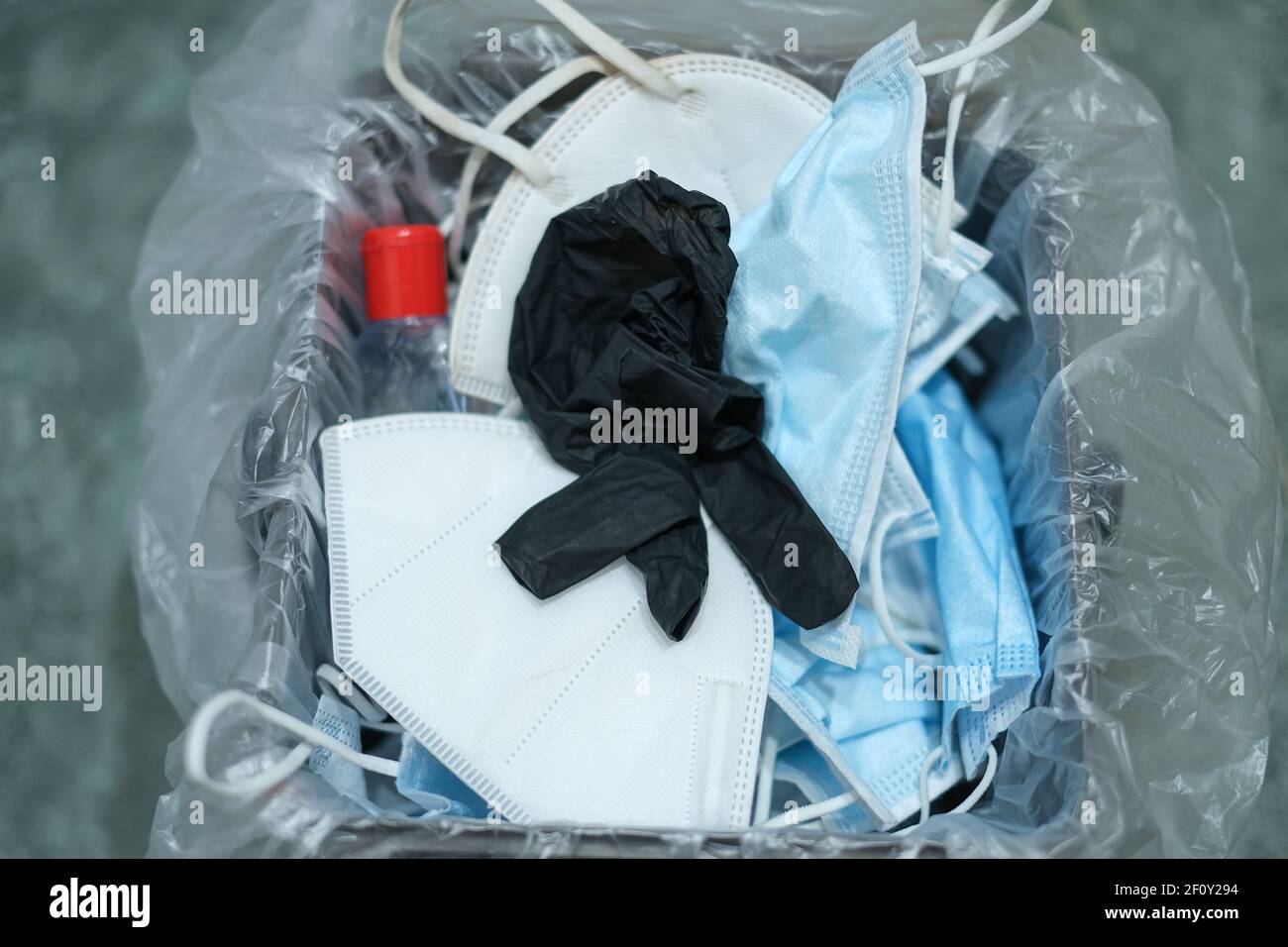 Separare il cestino pieno di maschera protettiva per il viso usata e. guanti, covid19 rifiuti di smaltimento medico Foto Stock