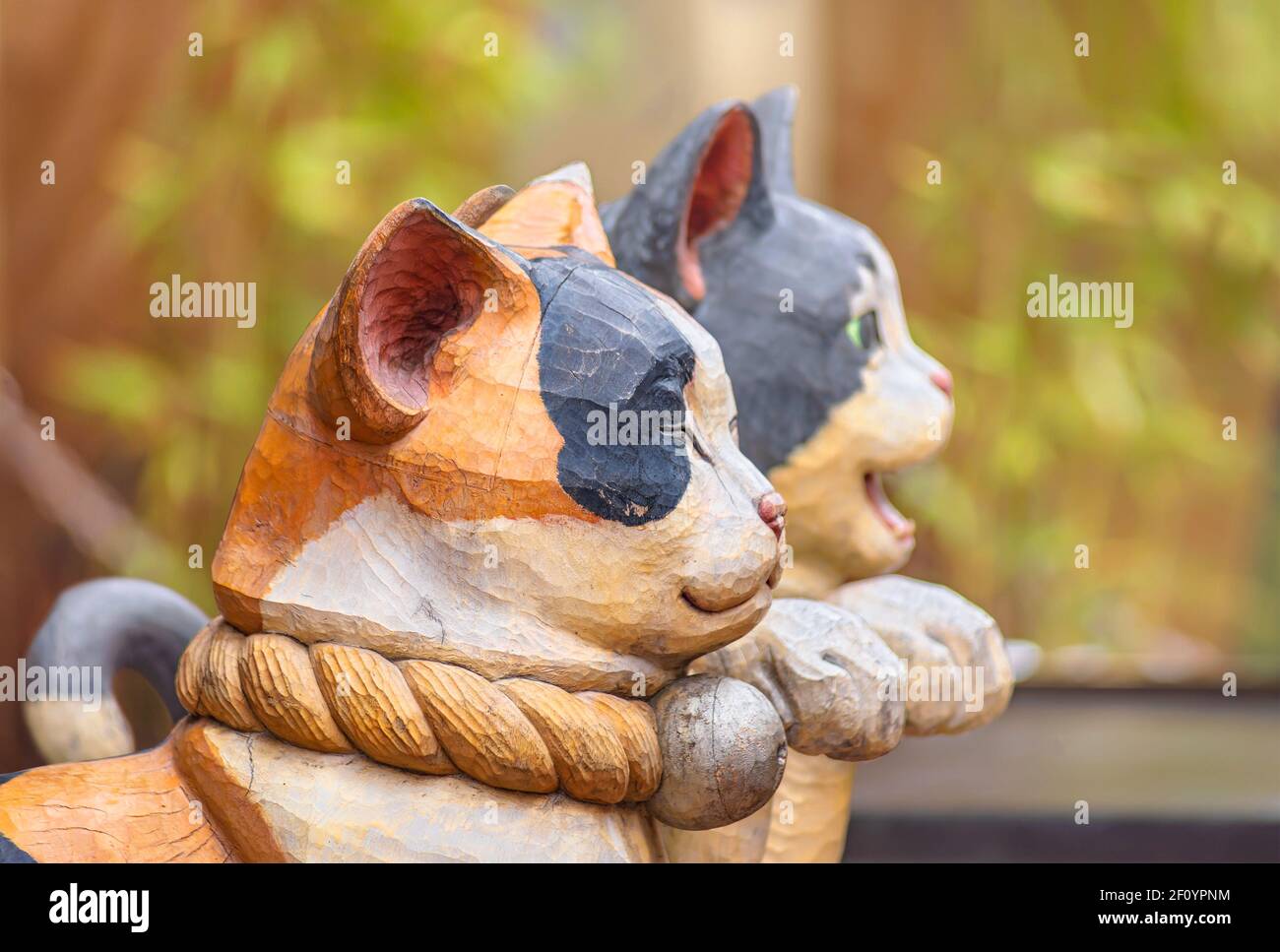 tokyo, giappone - febbraio 28 2021: Vista di profilo di un paio di statue in legno a bocca chiusa e a bocca aperta raffiguranti gatti giapponesi maneki-neko wit Foto Stock