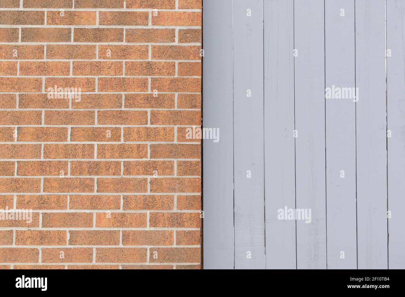 Muro di mattoni e sfondo di struttura recinzione di legno Foto Stock