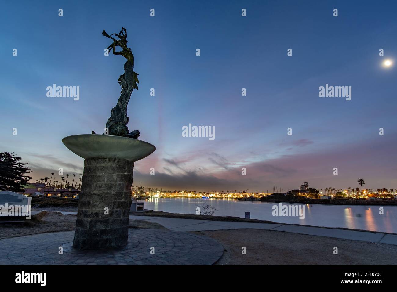 Statua silhouette guardando sopra il porto dell'Oceano Pacifico di Ventura con le luci del mattino all'orizzonte. Foto Stock