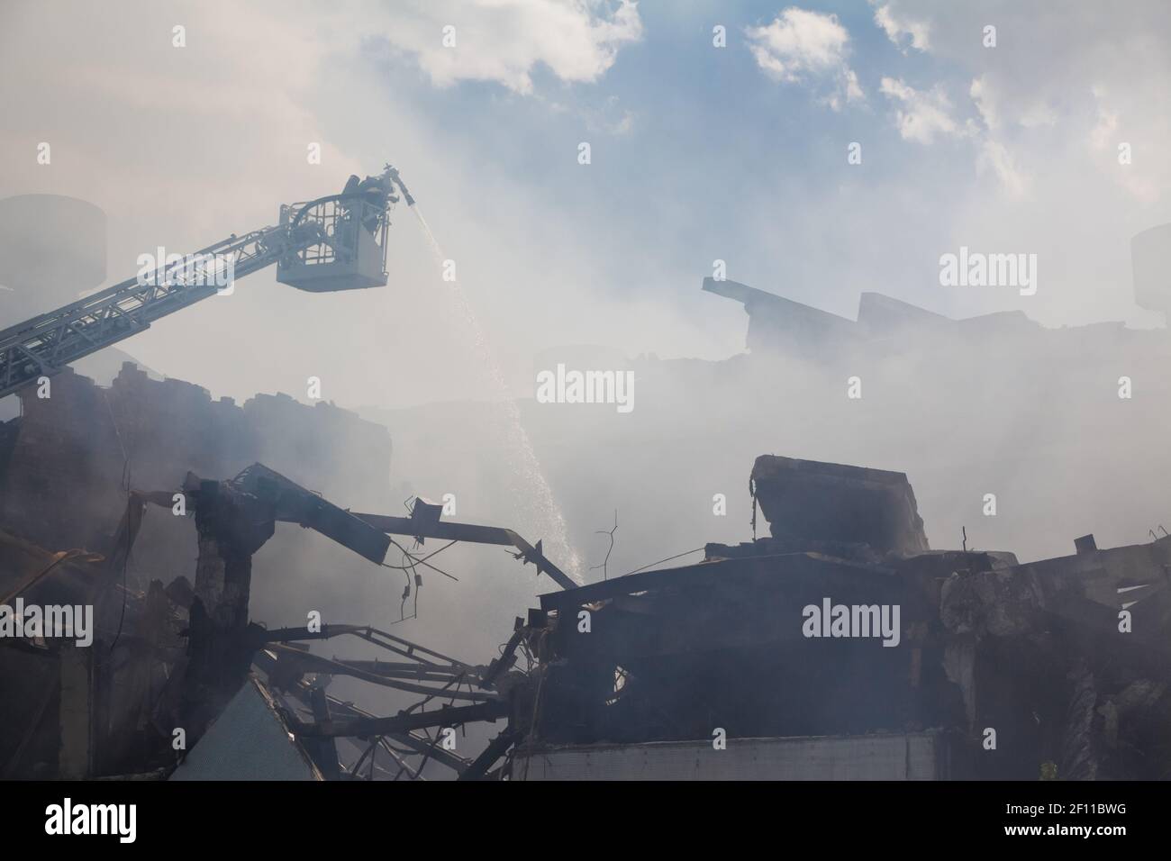 Disastro tecnologico, incendio, edificio industriale distrutto, fumo, estinzione incendi Foto Stock