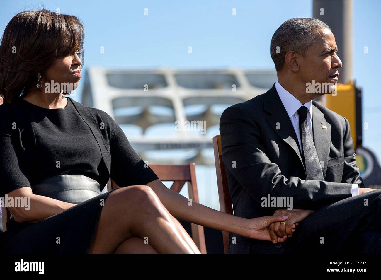 Il presidente Barack Obama e la prima signora Michelle Obama tengono le mani mentre ascoltano il Rep. John Lewis, D-GA. Parlando durante un evento per commemorare il 50 ° anniversario della domenica di Bloody e le marce dei diritti civili di Selma a Montgomery, al ponte Edmund Pettus a Selma, Ala., 7 marzo 2015. Foto Stock