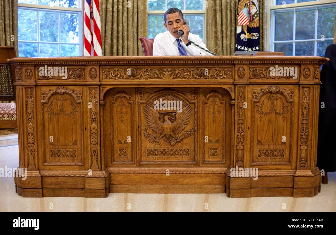 Il presidente Barack Obama siede dietro il Resolute Desk nell'Ufficio ovale durante una conferenza telefonica con la gente di fede agosto 19 2009. Foto Stock