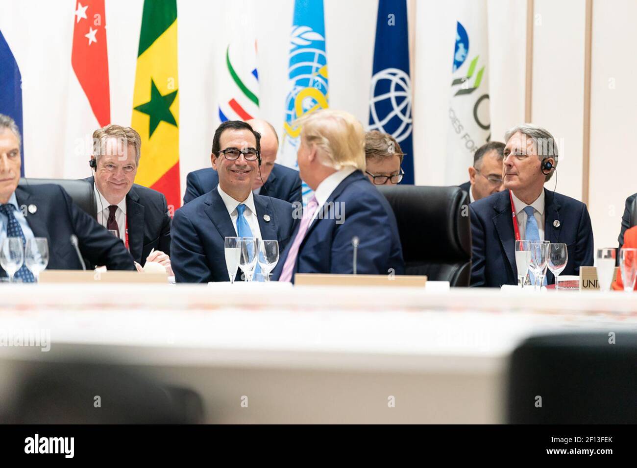 Il presidente Donald Trump si rivolge a parlare con l'ambasciatore americano del rappresentante commerciale Robert Lighthizer e il segretario del Tesoro americano Steven Mnuchin a un pranzo di lavoro sul commercio e gli investimenti dell'economia globale al vertice del G20 del Giappone venerdì 28 2019 giugno a Osaka Giappone. Foto Stock