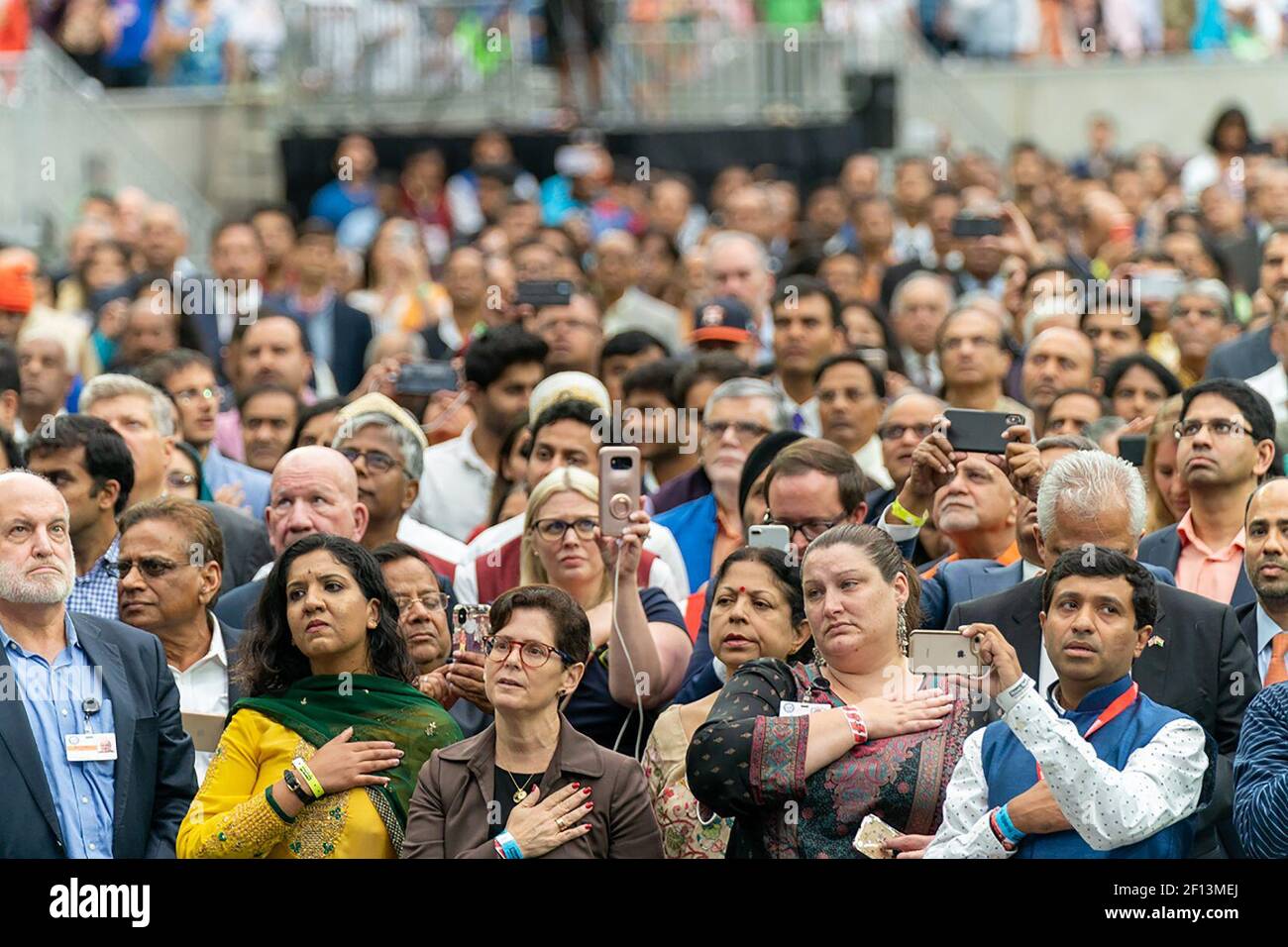 I membri del pubblico hanno le mani sui loro cuori mentre gli Anthem nazionali degli Stati Uniti e dell'India sono giocati domenica 22 2019 settembre ad un rally in onore del primo ministro Narendra modi al NRG Stadium di Houston, Texas. Foto Stock