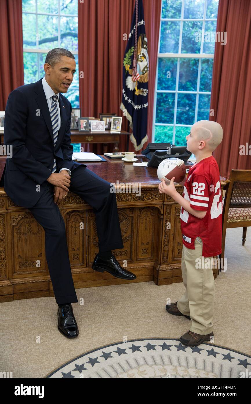 Il presidente Barack Obama saluta il 7-year-old Jack Hoffman di Atkinson Neb. Nell'ufficio ovale aprile 29 2013. Hoffman che sta combattendo il cancro del cervello pediatrico ha guadagnato l'attenzione nazionale dopo che ha funzionato per un touchdown di 69-yard durante una partita di football primaverile di Cornhuskers del Nebraska. Hoffman detiene un calcio che il presidente ha firmato per lui. Foto Stock