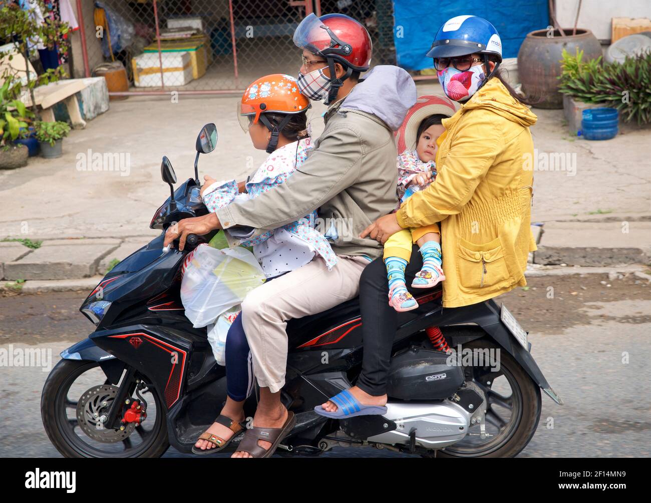 Famiglia vietnamita di quattro persone in moto. Delta del Mekong, Vietnam Foto Stock