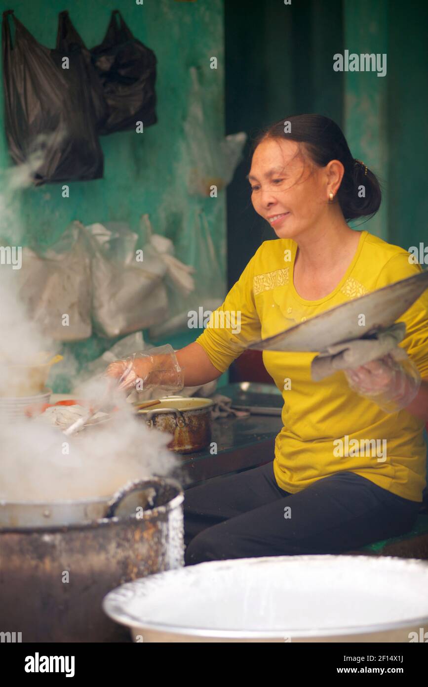 Donna vietnamita che cucina gnocchi in un recipiente per la cottura a vapore. Thanh Liêm, Hà Nam, Provincia di ha Nam, Vietnam del Nord Foto Stock