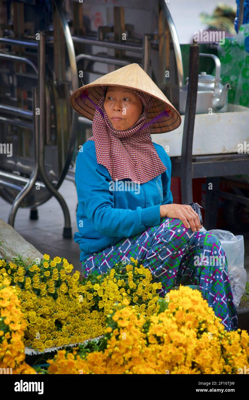 Venditore di fiori vietnamita in caratteristico cappello conico. Mercato di Hoi An, Vietnam Foto Stock