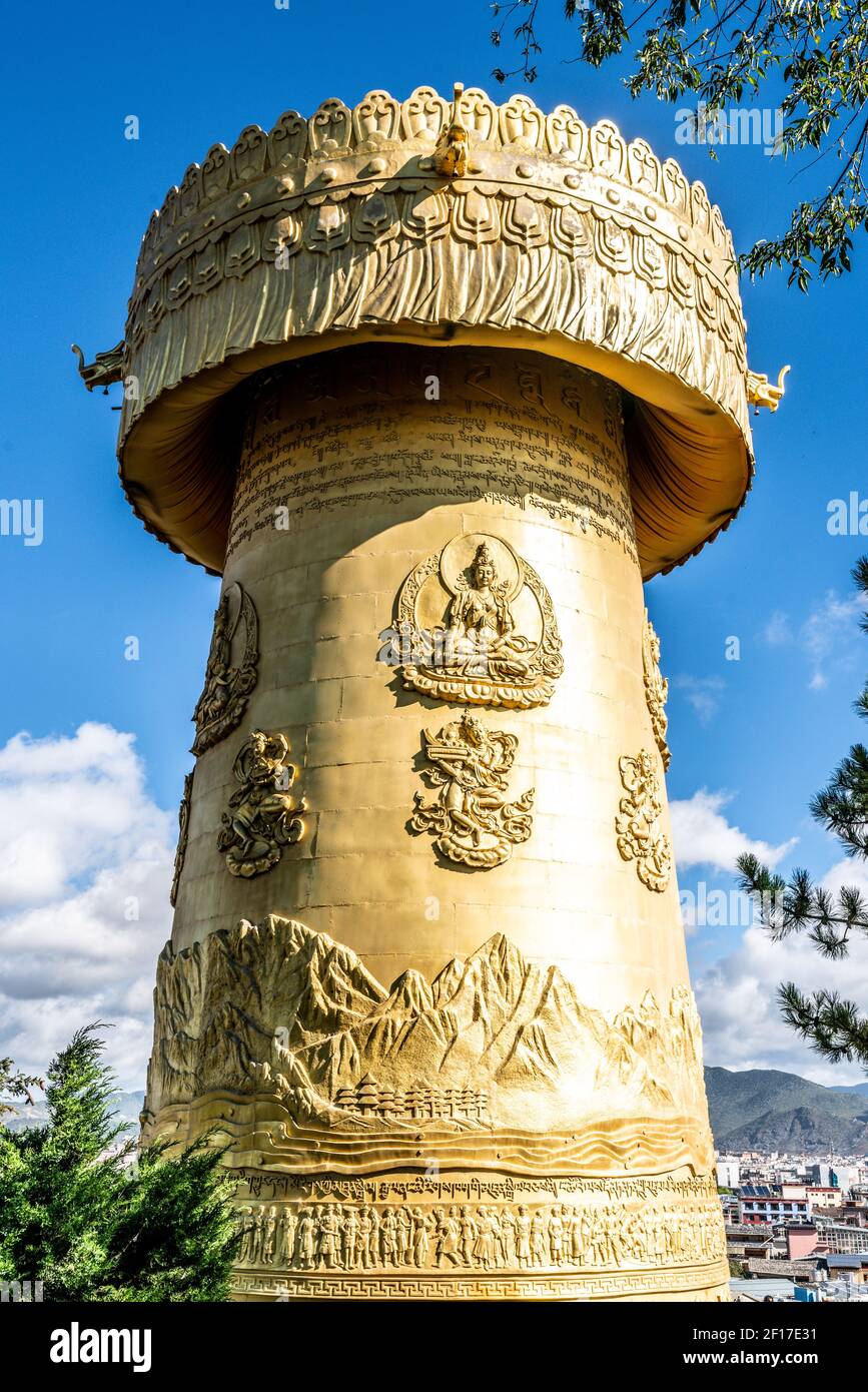 Ruota gigante di preghiera buddista tibetana del tempio verticale di Guishan Dazo Vista sul cielo blu nella città vecchia di Dukezong a Shangri-la Yunnan Cina Foto Stock