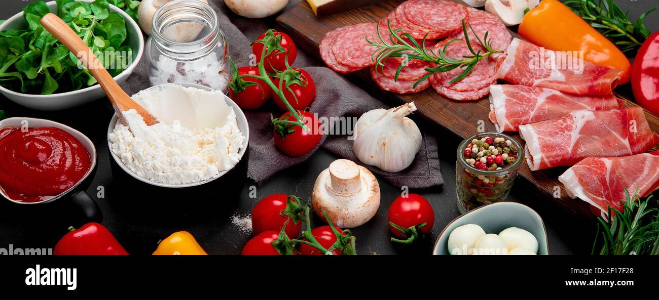 Preparazione della pizza italiana. Varietà di ingredienti di cottura tradizionali. Ricetta deliziosa fatta in casa concept.Panorama, banner Foto Stock