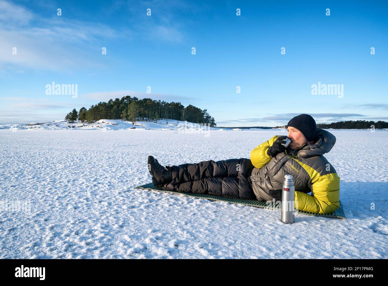 Gusterete il tè mattutino sul Mar Baltico ghiacciato nell'arcipelago di Espoo, Finlandia Foto Stock