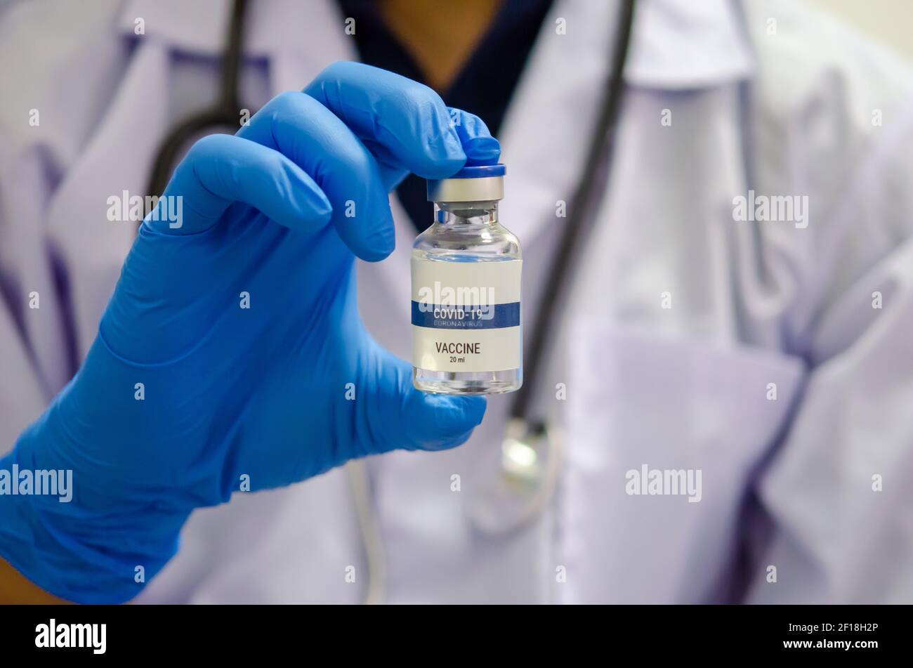 Medico o laborante che contiene una provetta per il vaccino COVID-19 o un vaccino per il coronavirus. Concetto di vaccino del coronavirus Foto Stock