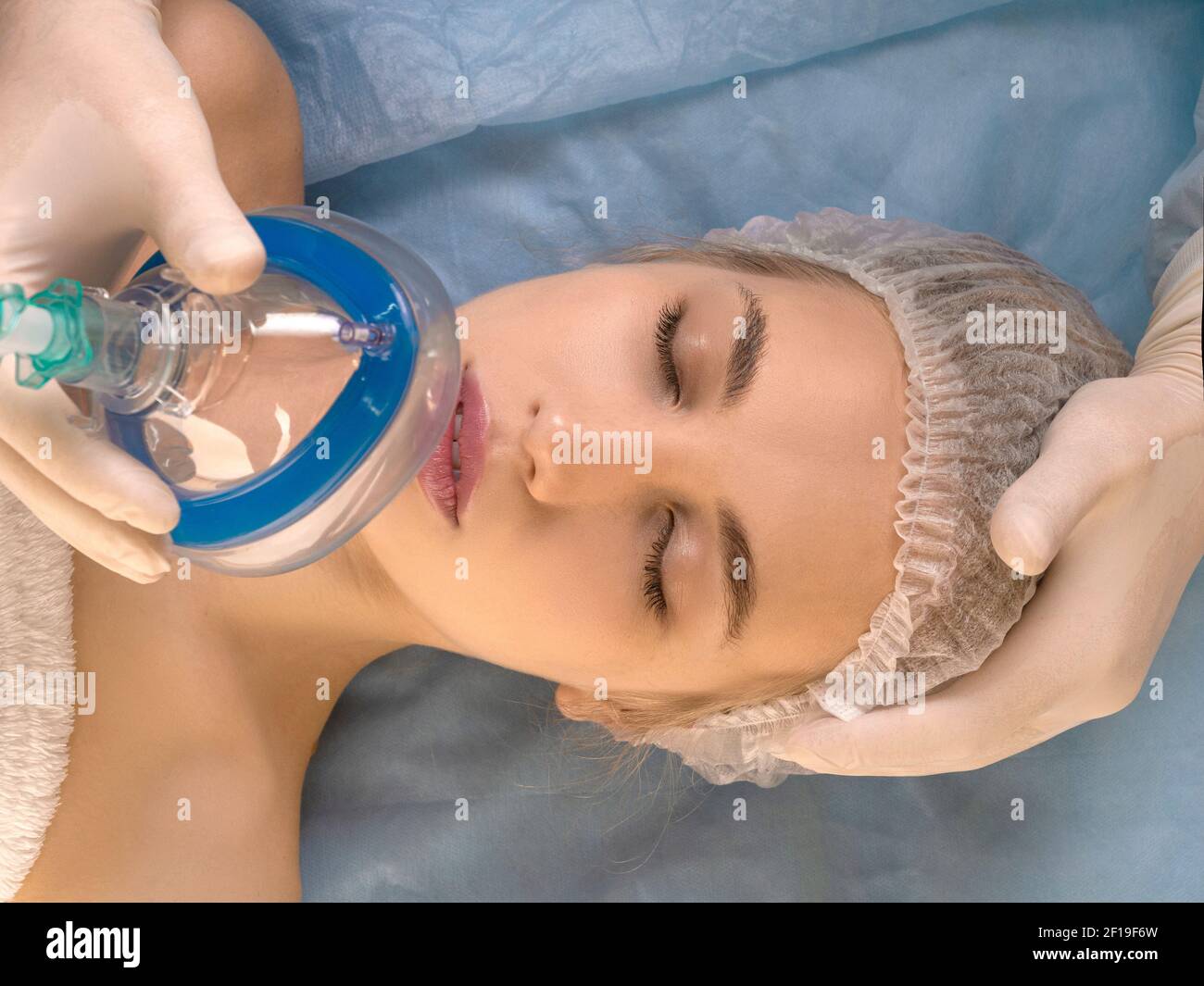 Primo piano - il medico dà l'anestesia al paziente prima di un intervento chirurgico o di una procedura di bellezza. Concetto di tecnologia medica moderna. Foto Stock