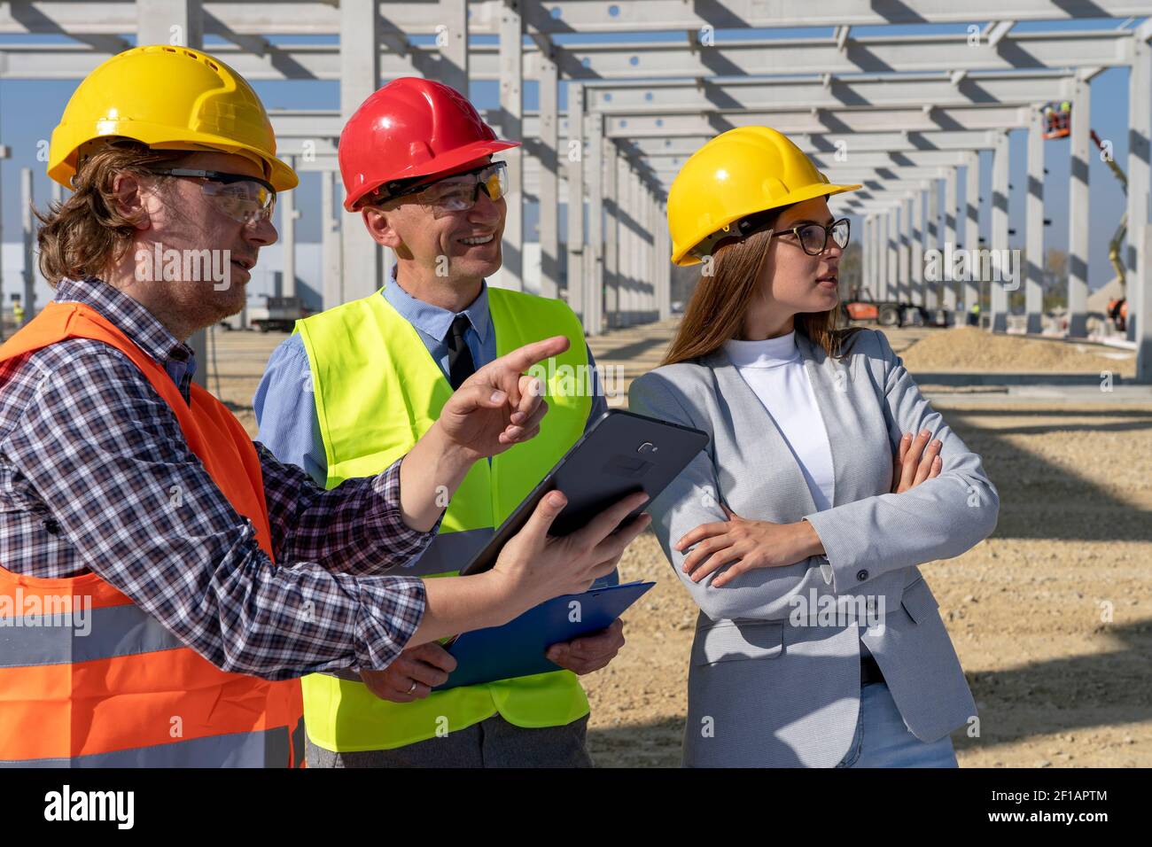 Ritratto di Foreman con Digital Tablet, Manager e Young Female Architect presso il cantiere. Relazione d'affari e concetto di lavoro di squadra. Foto Stock