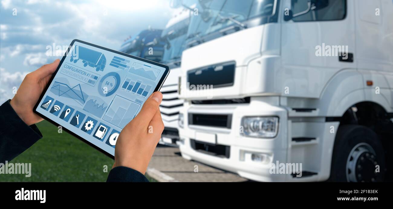 Manager con un tablet digitale sullo sfondo dei veicoli industriali. Gestione della flotta Foto Stock