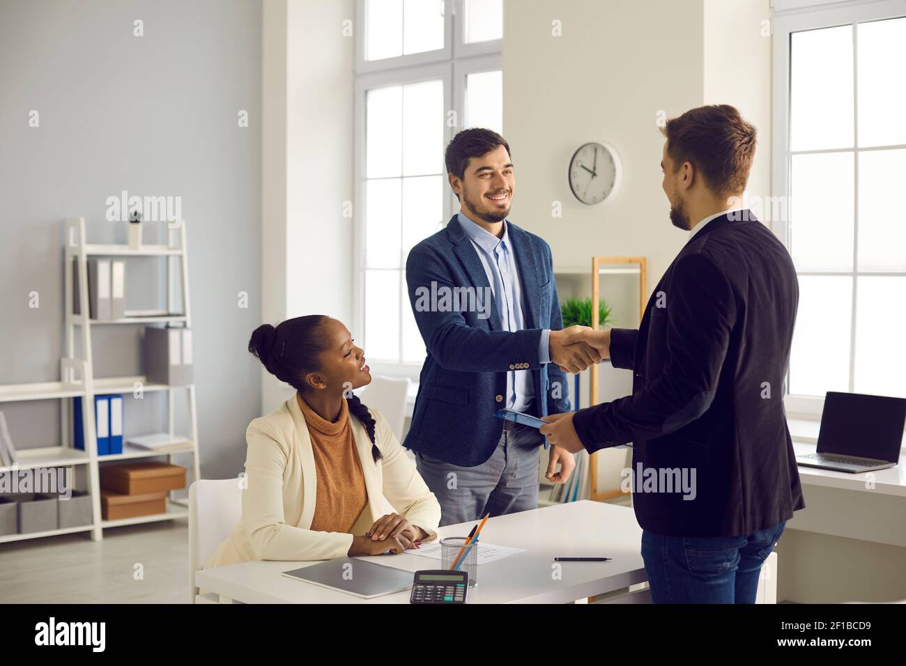 L'uomo caucasico e la sua moglie afroamericana ricevono i saluti da un consulente finanziario con ipoteca Foto Stock