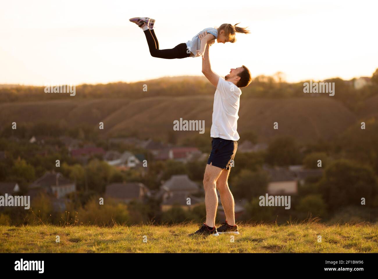 Padre e figlia si divertono insieme. Papà getta sua figlia in cielo Foto Stock