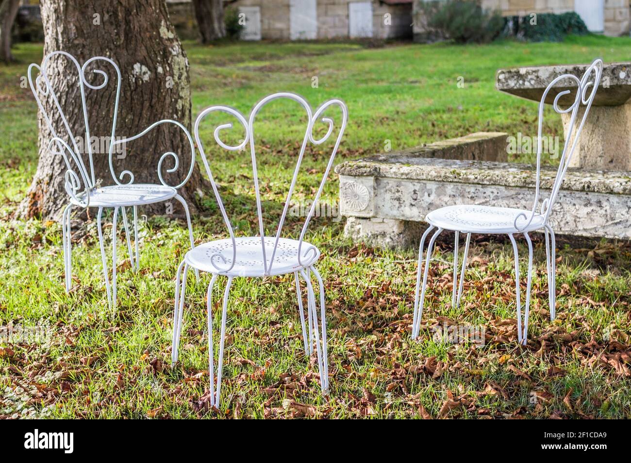 Vintage decorativa in metallo sedie bianche mobili in un giardino Foto Stock