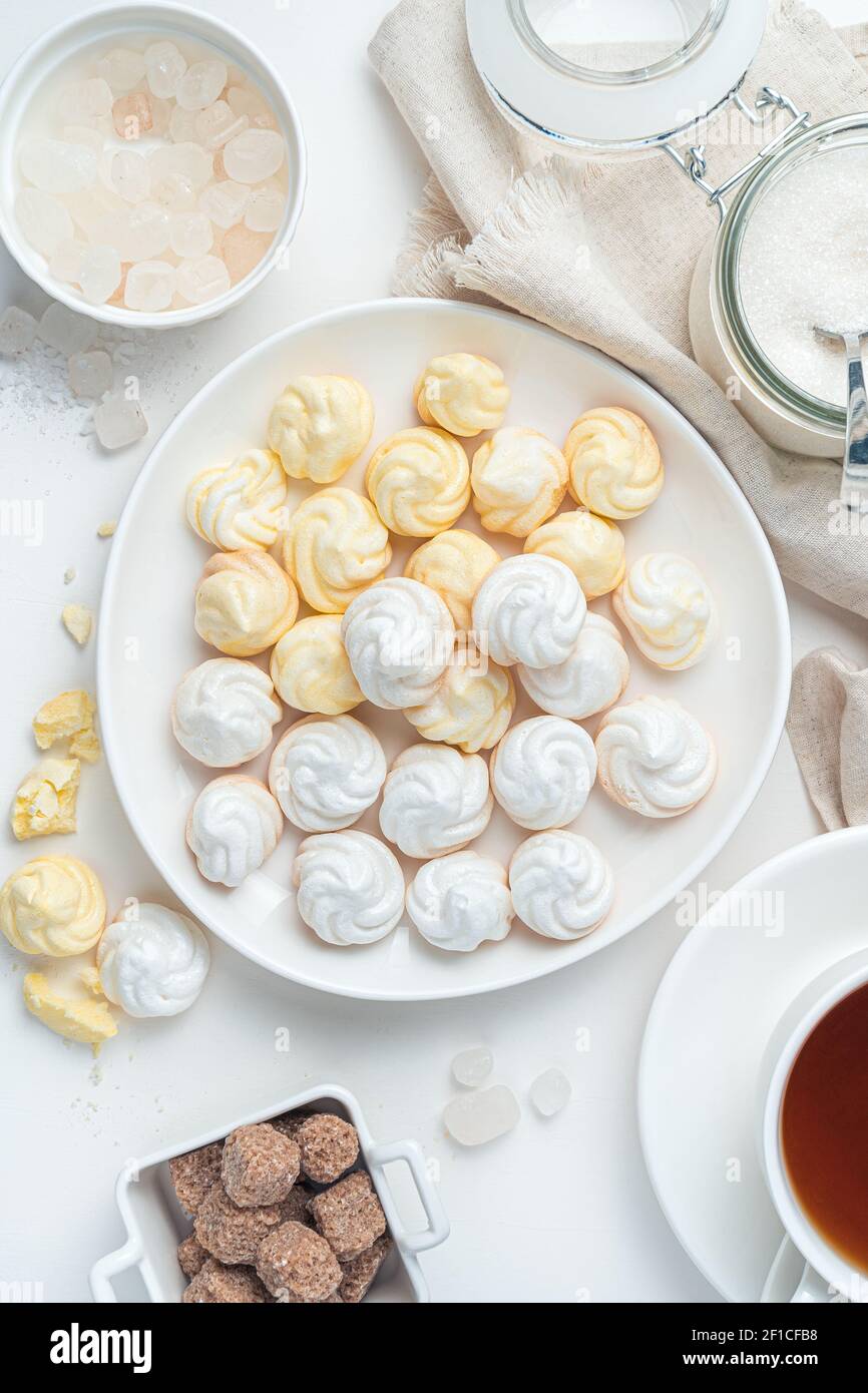 Meringhe francesi da dessert su sfondo chiaro. Il concetto di prodotti dolciari. Vista dall'alto. Foto Stock