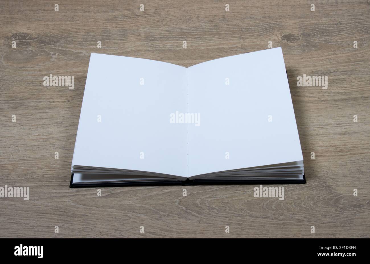 aprire il libro di schizzo con le pagine vuote su sfondo di legno Foto Stock