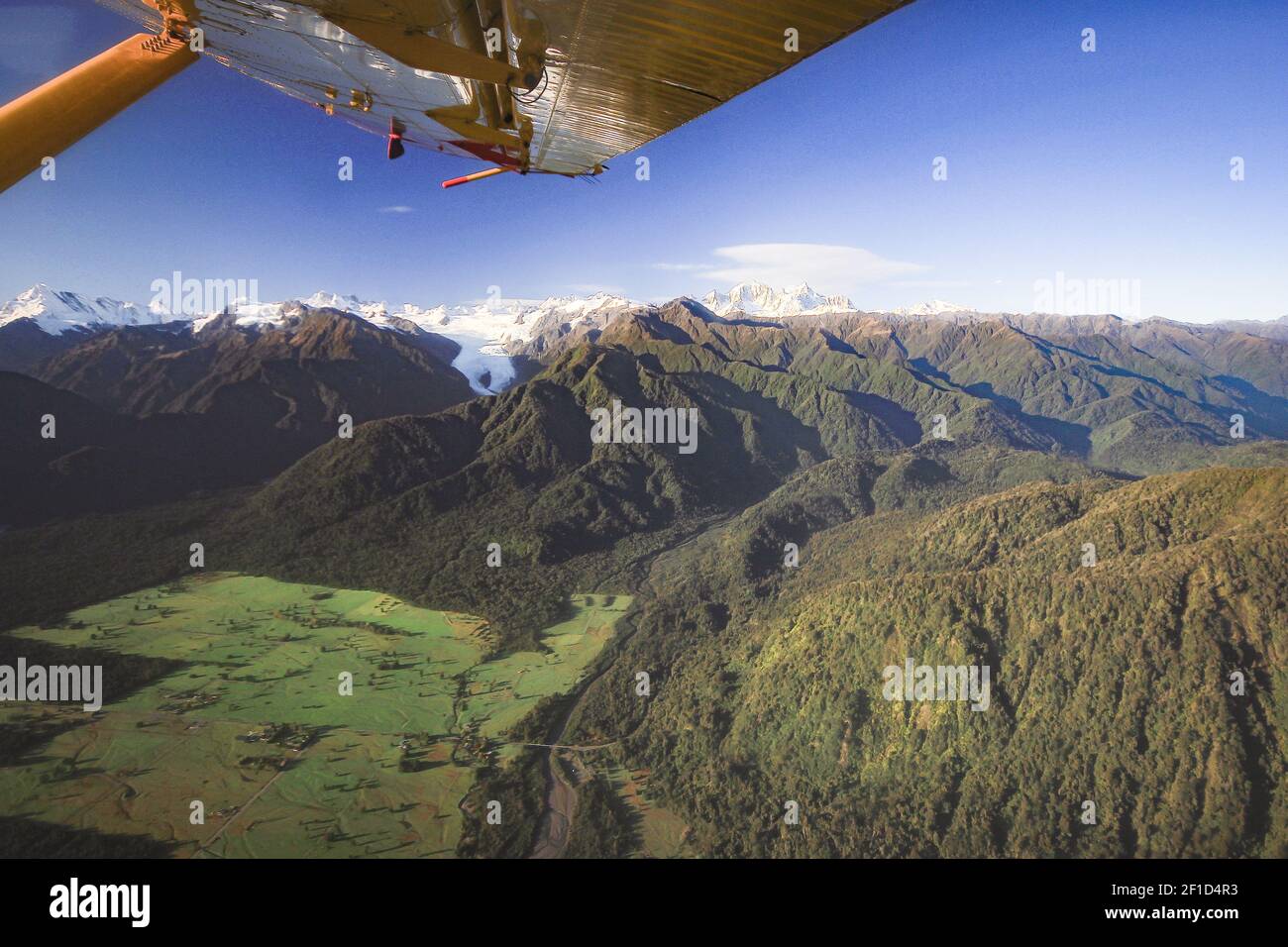 Vista aerea sulle catene montuose e sui campi verdi con alettone in telaio. Foto sopra il ghiacciaio Franz Josef nella regione della costa occidentale della Nuova Zelanda Foto Stock